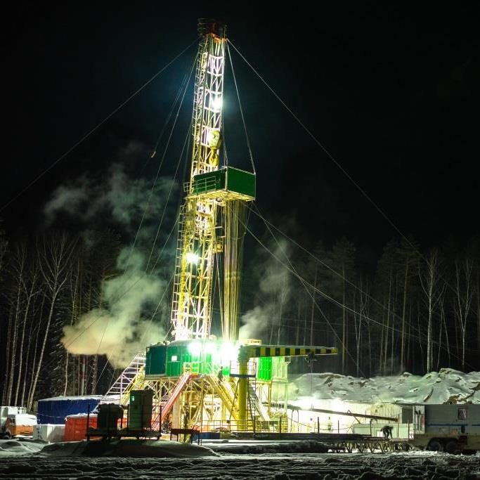 Land rig installing lower completions equipment at night